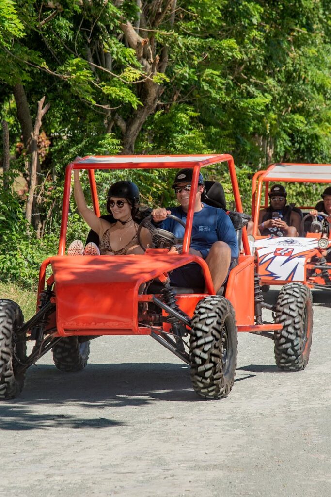 Group enjoying a thrilling buggy ride on a scenic forest road under clear skies.