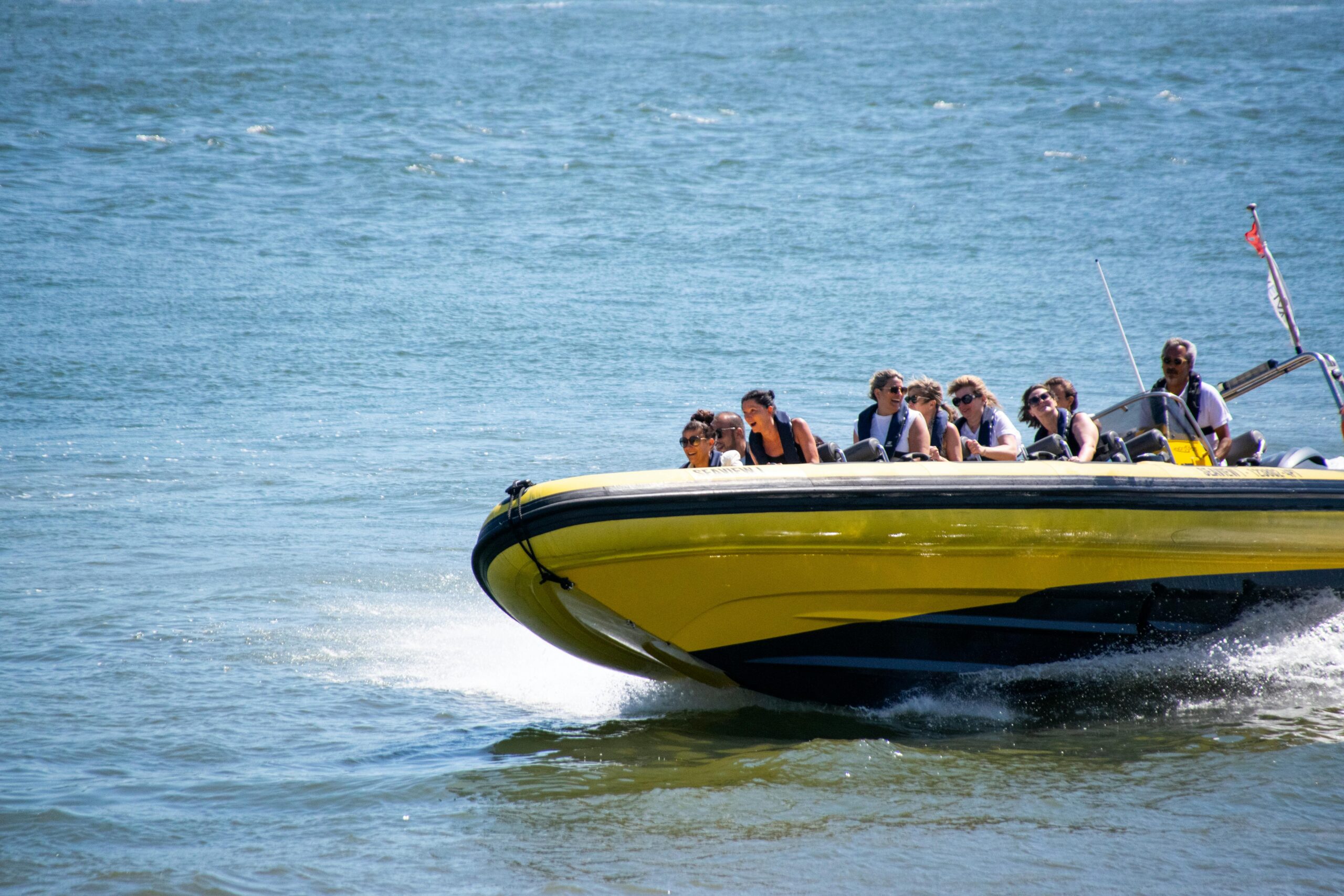 Thrilling speedboat ride with passengers exploring the Tejo River in Lisbon, Portugal.